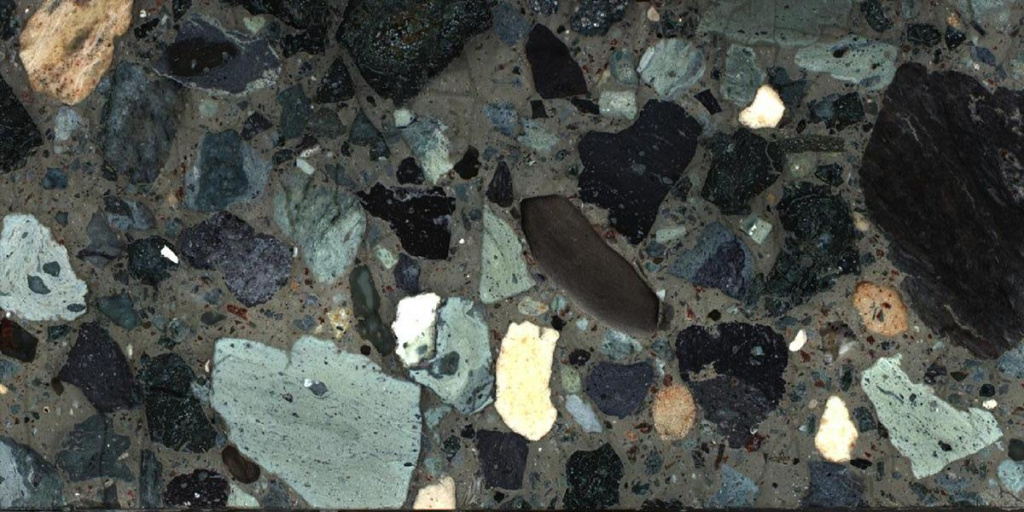 Фрагмент пробуренных кернов из скал, заполнивших кратер при падении астероида. Учёные обнаружили расплавленные и разбитые породы (песчаник, известняк и гранит) без серосодержащих минералов, несмотря на их высокую концентрацию в этом районе. (фото: Международная программа Ocean Discovery)